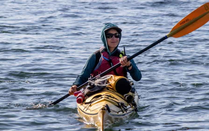 a student paddles a yellow kayak on an outward bound expedition 